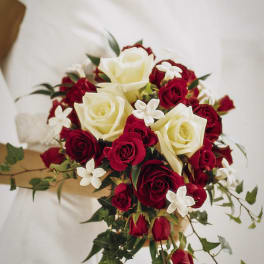 Bridal bouquet of red and white roses with small white flowers