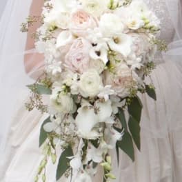 Bridal bouquet of white and blush flowers with trailing greenery