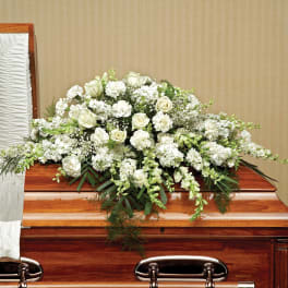 White floral casket spray with roses and carnations