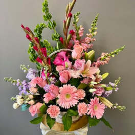Pink mixed flower arrangement in a gold container