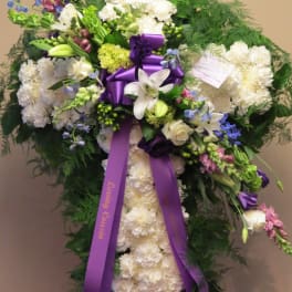 Standing white floral spray with purple ribbon and mixed blooms