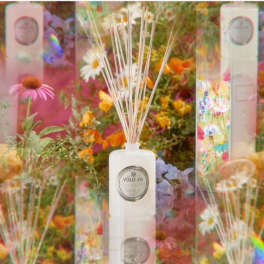 White reed diffuser bottle with floral packaging and colorful flowers
