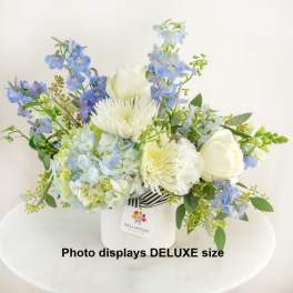 Blue and white floral arrangement in a white vase