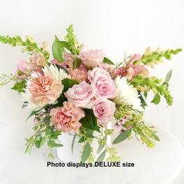 Pink roses and carnations with white daisies in a white vase
