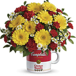 Bouquet of yellow daisies and red carnations in a Campbell's soup mug