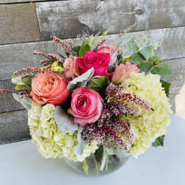 Bouquet of pink roses and pale hydrangeas in a glass vase