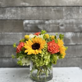 Sunflower and rose bouquet in a clear glass vase