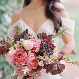 Woman holding a pink and burgundy bridal bouquet