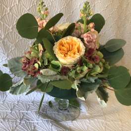 Bouquet of peach and pink flowers in a clear glass vase