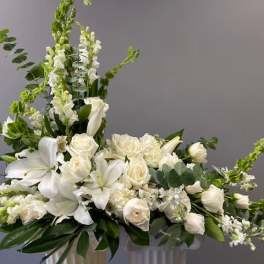 White floral arrangement with lilies and roses in a vase