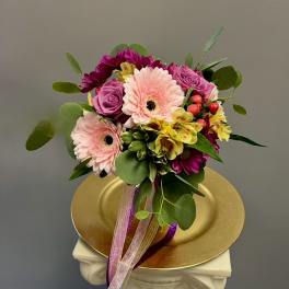 Bouquet of pink gerbera daisies, purple roses, and yellow alstroemeria