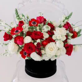 Red and white rose bouquet in a black hat box