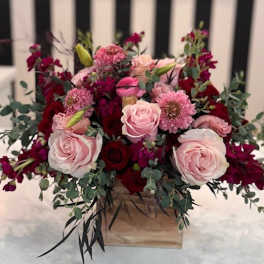 Pink and red rose arrangement in a wooden box