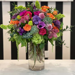 Colorful mixed flower arrangement in a clear glass vase