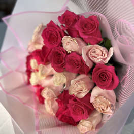 Bouquet of hot pink and blush roses wrapped in pink paper