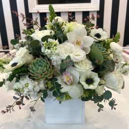 White floral arrangement with succulents in a white box