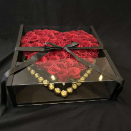 Box of red roses with a black ribbon and gold chocolates