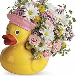 Yellow duck container filled with pink and white flowers
