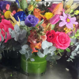 Colorful bouquet of roses and mixed flowers in a green vase