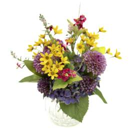 Mixed bouquet of yellow and purple flowers in a clear glass vase