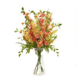 Orange and pink floral arrangement in a clear glass vase