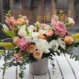 Mixed pastel bouquet in a decorative metal vase on a white table