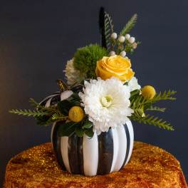 Yellow rose and white chrysanthemum arrangement in a striped pumpkin vase