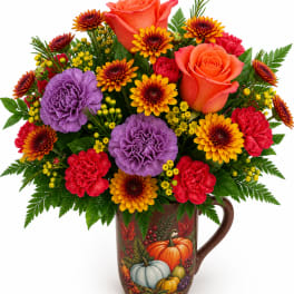 Colorful bouquet of roses, carnations, and mums in a pumpkin-decorated mug