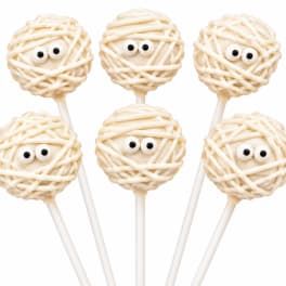 Five mummy-themed cake pops with candy eyes on white sticks