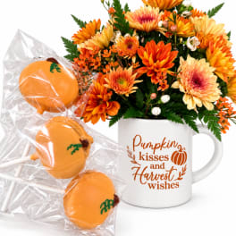 Orange and yellow flower arrangement in a mug with pumpkin cake pops