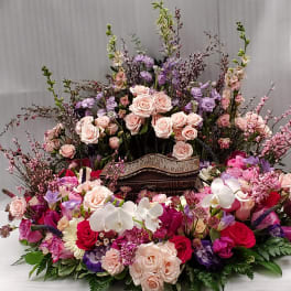 Large floral arrangement with pink and purple roses and white orchids