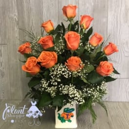 Orange roses arranged in a vase with baby's breath