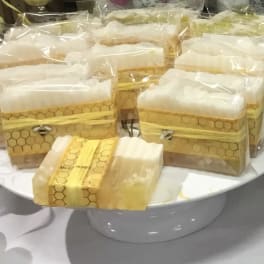 Wrapped honeycomb-pattern gift boxes on a white pedestal