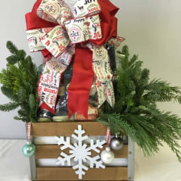 Christmas gift basket with a large red bow, evergreen branches, and a snowflake ornament
