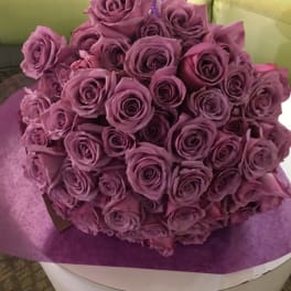 Bouquet of purple roses wrapped in purple paper