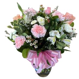 Pink and white mixed bouquet with a pink ribbon in a glass vase