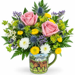 Pink roses and mixed flowers arranged in a painted mug vase