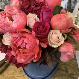 Artistically arranged peonies and hydrangea in a Tiffany hat box