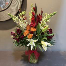 Mixed bouquet in a glass vase with lilies, chrysanthemums, and snapdragons