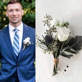 White boutonniere with greenery on a blue suit lapel
