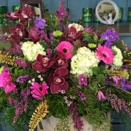Large mixed floral arrangement with orchids, hydrangeas, and gerbera daisies