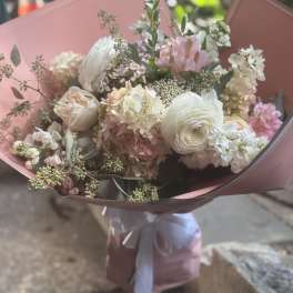 Bouquet of white and blush flowers wrapped in pink paper
