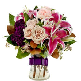 Bouquet of pink lilies and pale roses in a glass vase