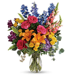 Colorful bouquet of roses, lilies, and snapdragons in a glass vase