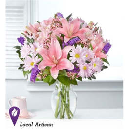 Pink lilies and daisies in a clear glass vase