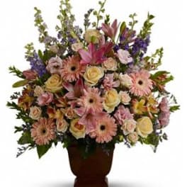 Mixed pink and cream flowers in a brown urn vase