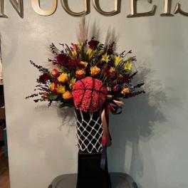 Basketball-themed floral arrangement in a black pedestal vase