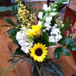 Bouquet with a sunflower, white blooms, and yellow flowers in a vase