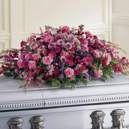 Large pink and purple floral spray on a casket