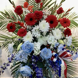 Large red, white, and blue floral standing spray with ribbon
